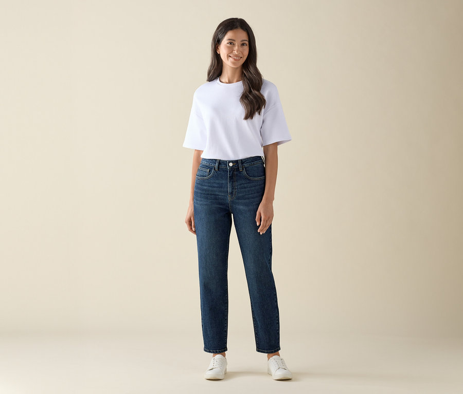 Frau trägt Mom Jeans – Fit »Nyla« in Dunkelblau und ein weißes T-Shirt.