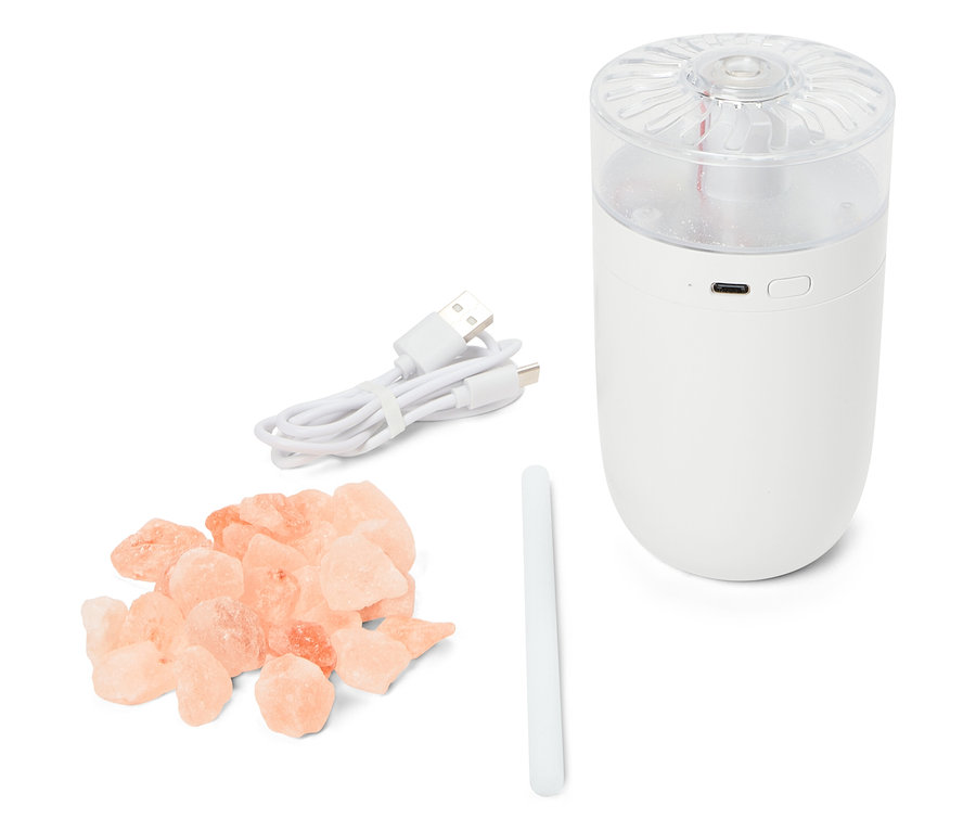 Ein weißer Luftbefeuchter mit USB-Kabel, einem Stab und einem Haufen rosa Salzkristalle.