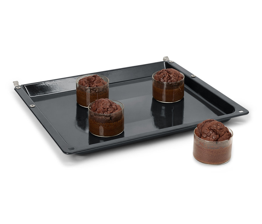 Vier Schokoladenmuffins in Gläsern auf einem schwarzen Backblech.