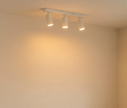 Ein beiges Sofa steht neben einem Holztisch, auf dem eine kleine Pflanze in einem Tontopf steht.