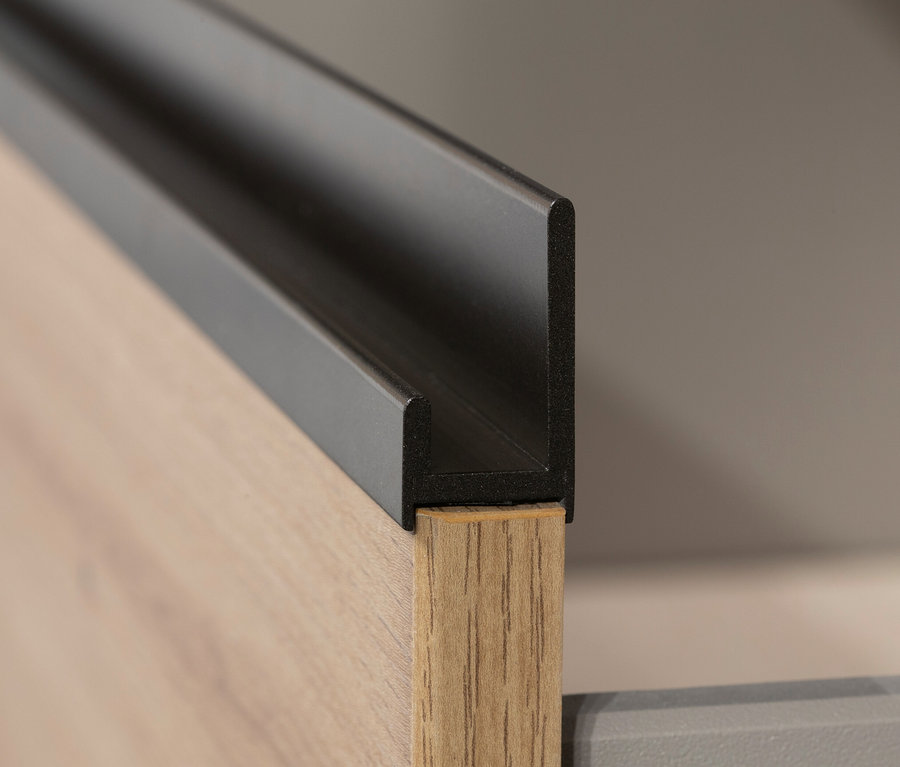 Detail einer grauen Schublade des Kleiderschranks »Joel« mit Holzdekor Eiche Artisan und einem schwarzen Griff.