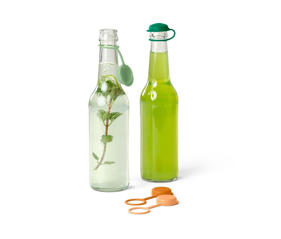 Zwei Glasflaschen mit Getränken und 4 Flaschenverschlüssen.