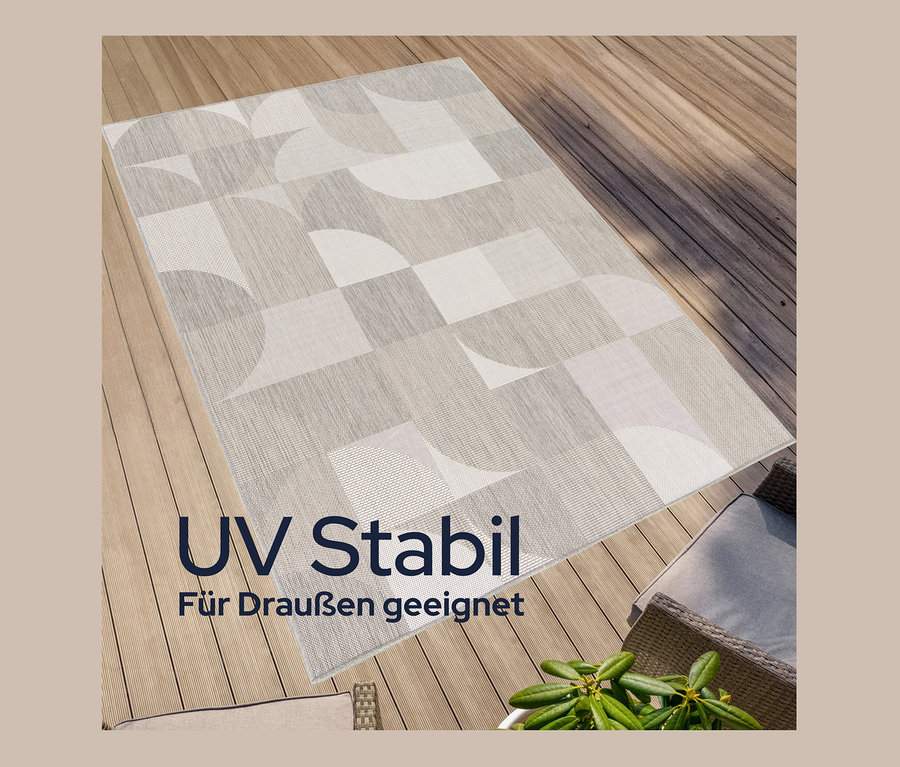 Ein faltbarer Outdoor-Teppich im geometrischen Design liegt auf einem Holzdeck.