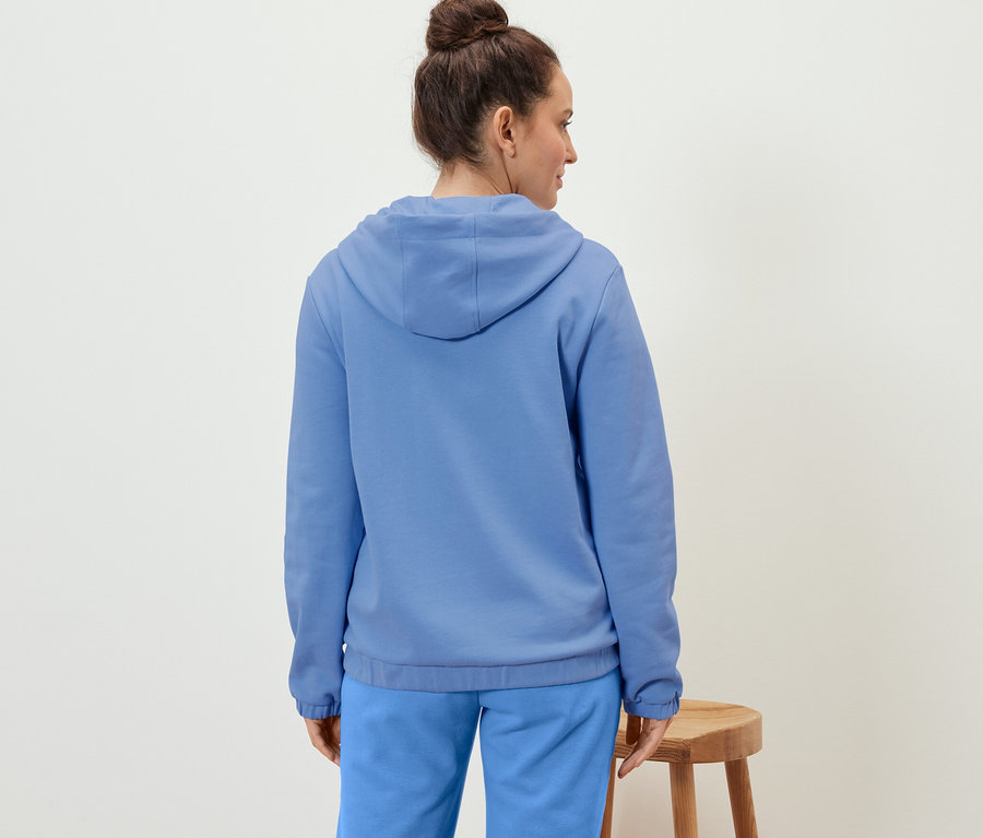 Frau trägt eine hellblaue Sweatjacke.