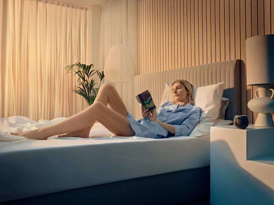 Frau liest auf TEMPUR Form™ Plus Matratze ein Buch.