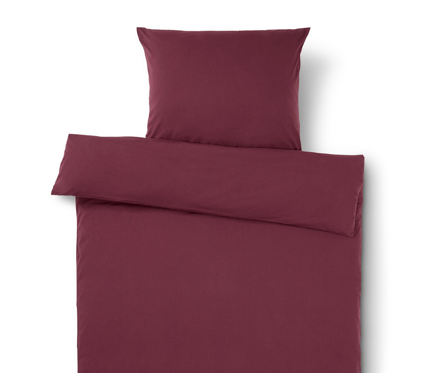 Burgunderfarbene Bettwäsche mit Kissen oben.