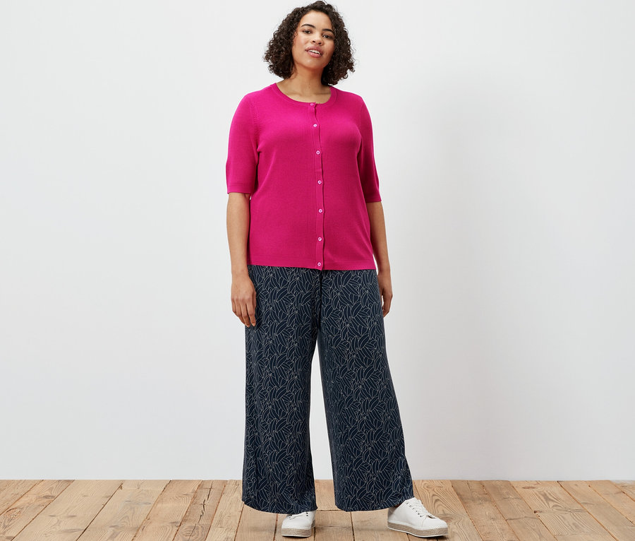 Frau trägt Feinstrick-Cardigan mit Leinen und bedruckte Palazzohose, dunkelblau-cremeweiß.