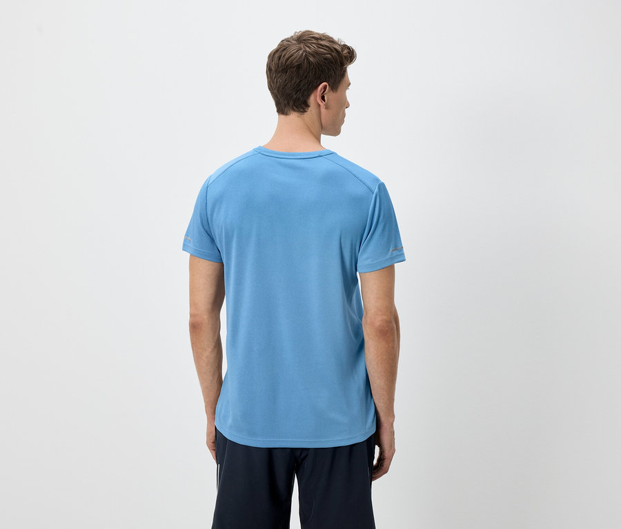 Rückansicht eines Mannes mit hellbraunen Haaren, der ein blaues T-Shirt und schwarze Shorts vor einem weißen Hintergrund trägt.