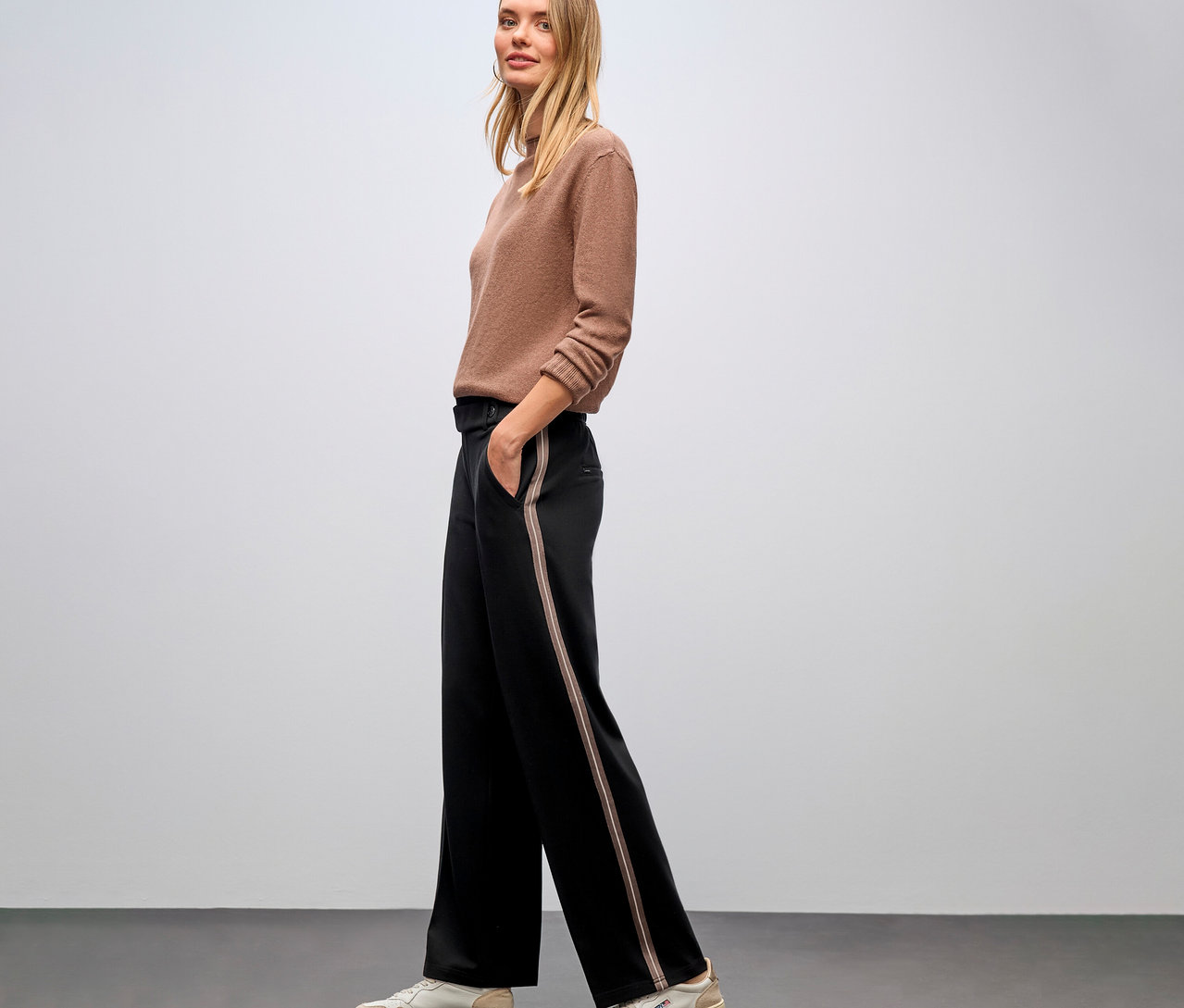 Frau posiert seitlich in braunem Pullover und schwarzen Street One Straight Leg Hosen mit Gallon.