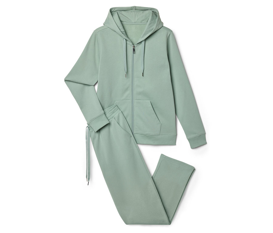 Ein hellgrüner Trainingsanzug, bestehend aus einer Kapuzenjacke mit Reißverschluss und einer Jogginghose, liegt auf einem weißen Hintergrund.