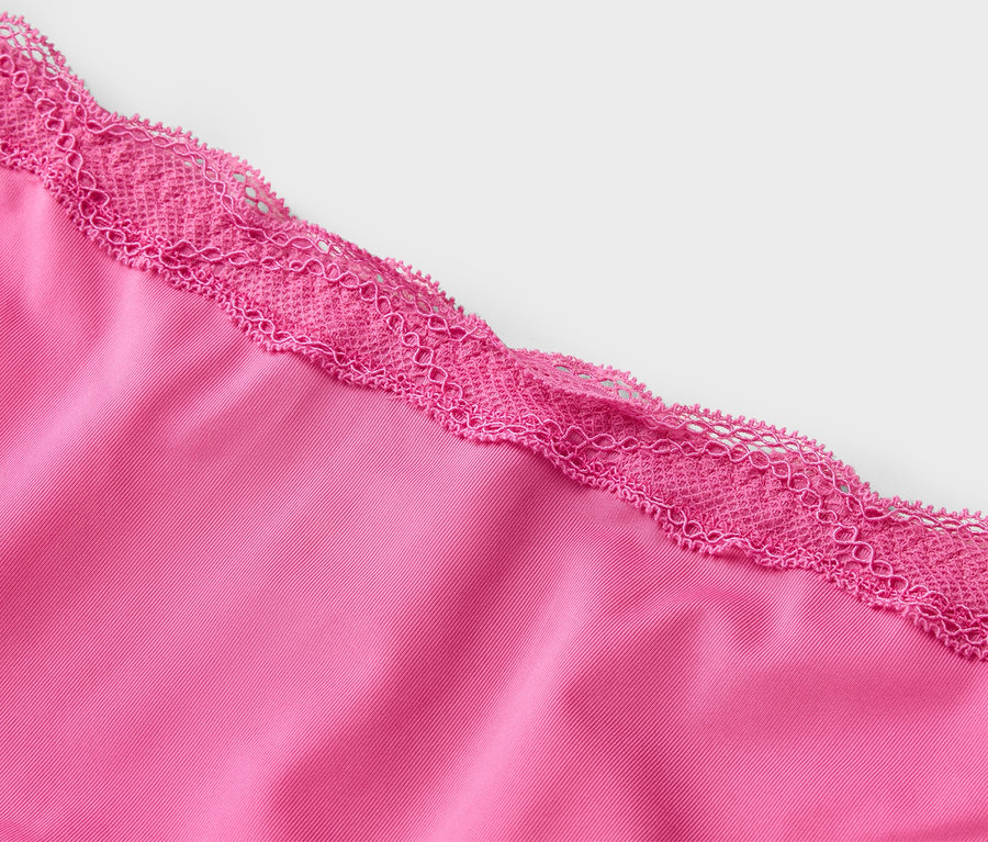 Nahaufnahme eines pinkfarbenen Stoffes mit rosa Spitze an der Kante.