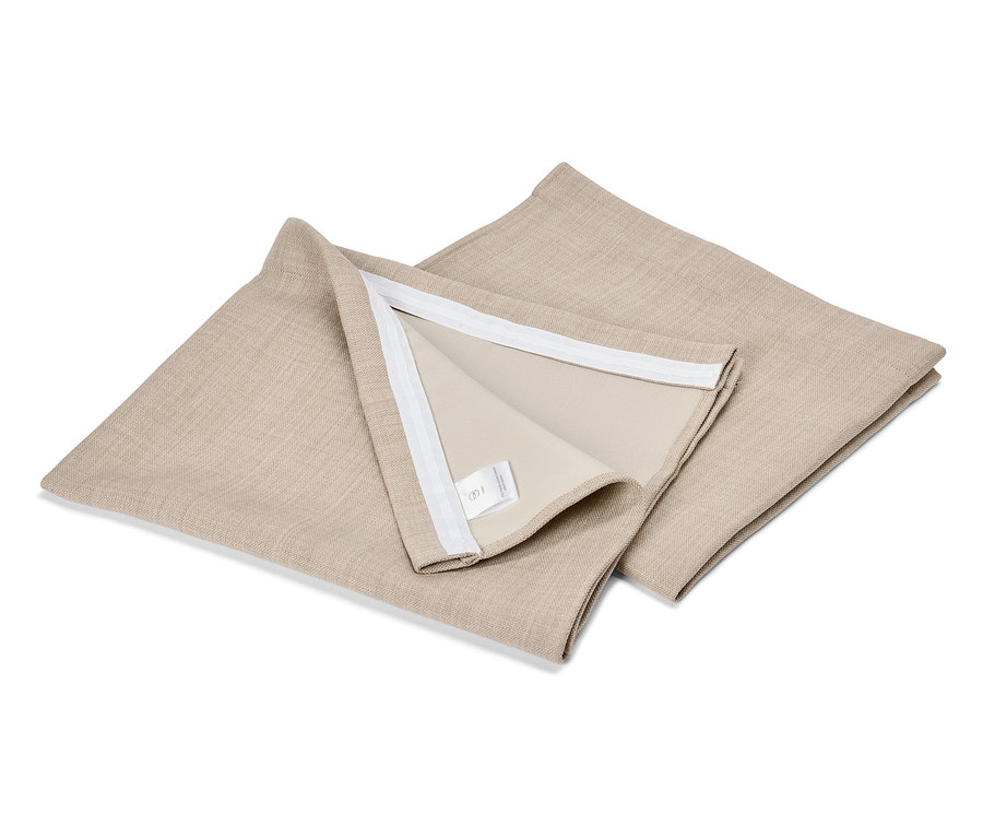 Zwei quadratische, beige Kissenbezüge liegen übereinander auf einer weißen Oberfläche.