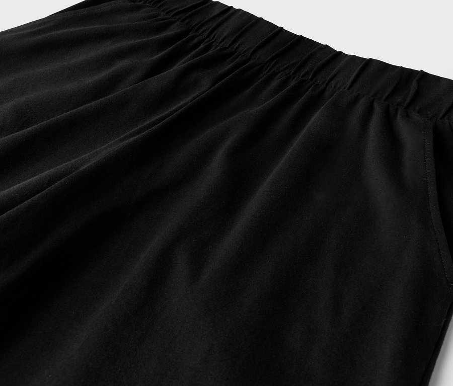 Detailaufnahme einer schwarzen Hose mit Gummizug und Seitentasche.
