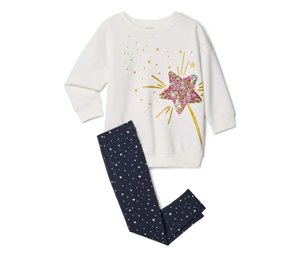 Weißes Langarmshirt mit großem rosa-goldenem Paillettenstern-Design, kombiniert mit dunkelblauen Leggings mit kleinen weißen Sternen.