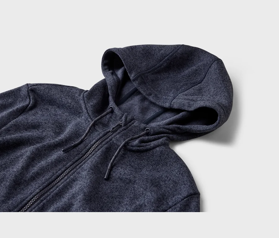 Dunkelblauer Kapuzenpullover mit Reißverschluss und Kordelzug, auf einer hellgrauen Oberfläche liegend.