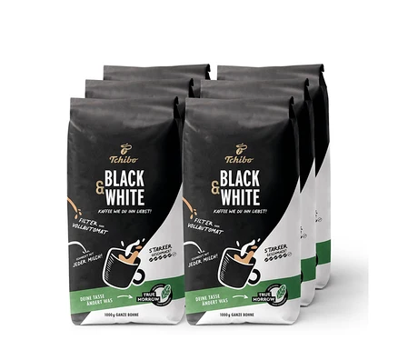 Sechs Packungen Tchibo Black & White Kaffeebohnen, je 1 kg. Die Packungen sind schwarz mit weißer und orangefarbener Schrift.