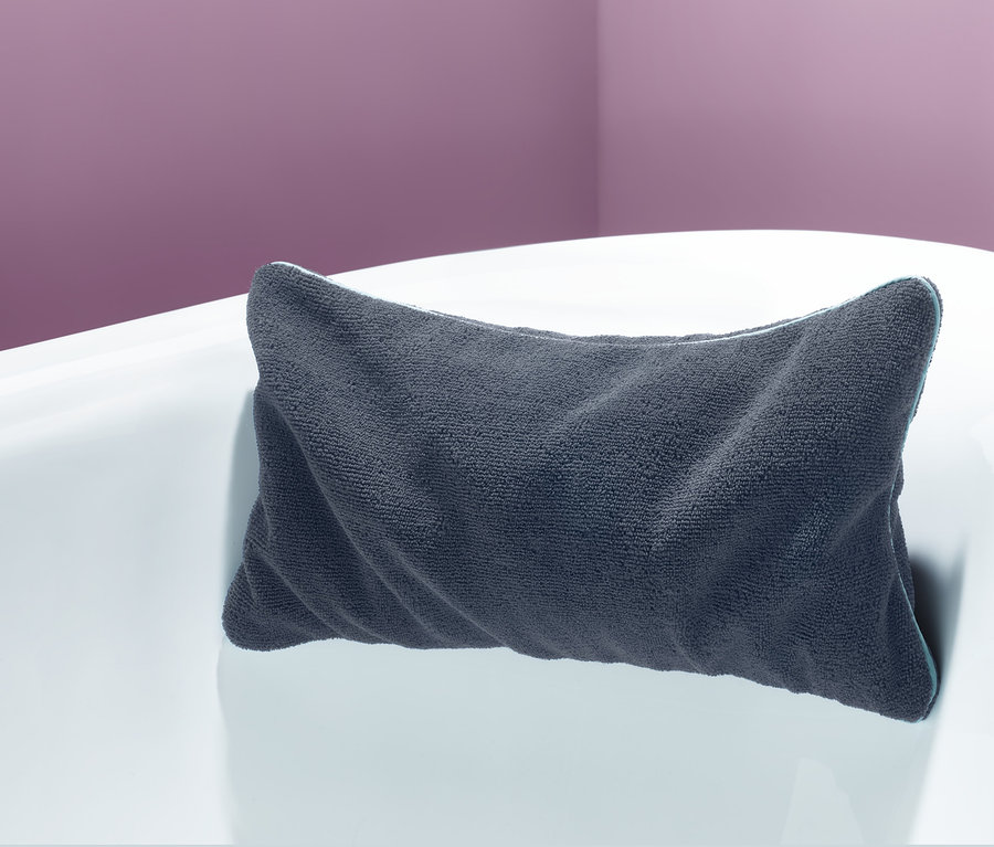 Graues Badewannenkissen auf einer weißen Badewanne.