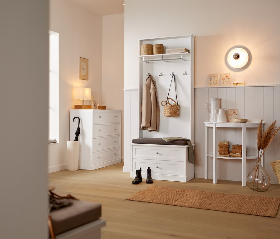 Flur mit Wand- und Deckenleuchte in Stuckoptik und Garderobe mit Sitzbank.