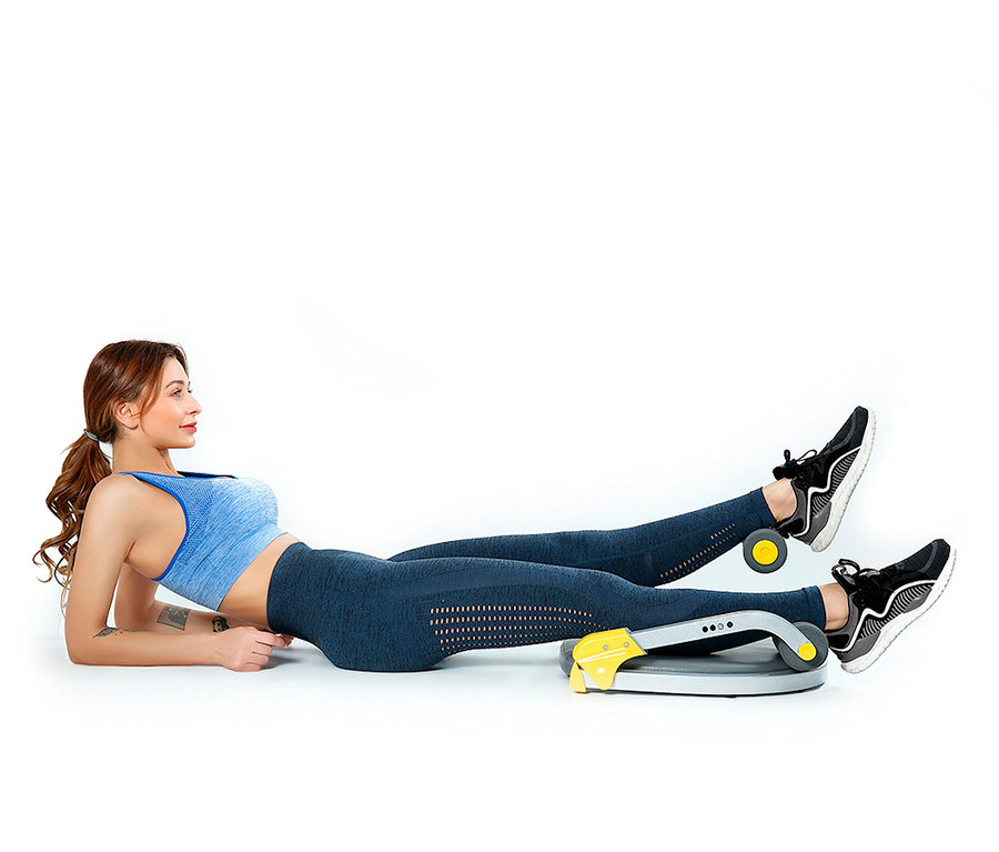 Frau liegt auf dem Boden und trainiert mit dem Body Coach Fitnessgerät Core Trimmer.