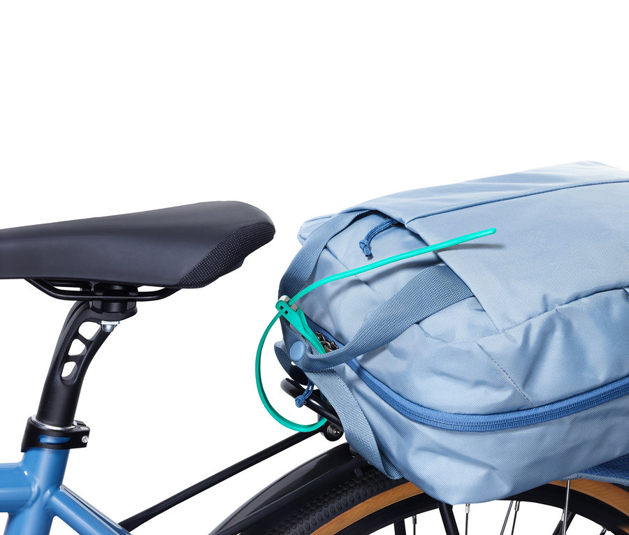 Blaues Fahrrad mit einem Kabelbinderschloss, das eine blaue Fahrradtasche sichert.