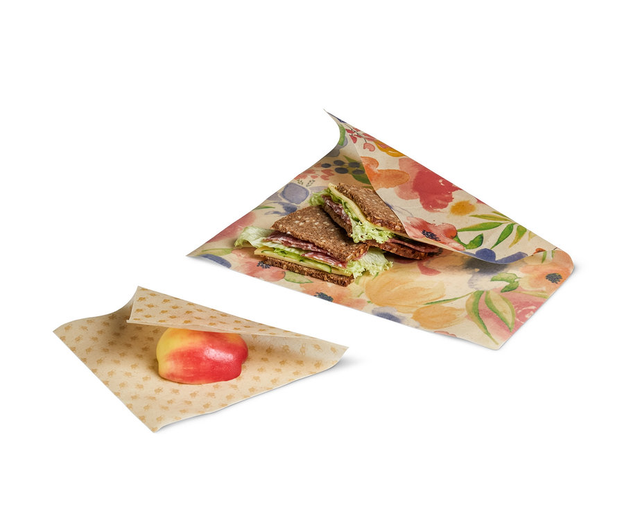 Ein Sandwich und ein Apfel sind in 2 Gaia-Bienenwachstücher eingewickelt.