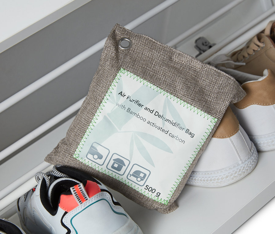 Ein Luftreinigungs- und Entfeuchterkissen liegt auf Schuhen in einem Schuhregal.