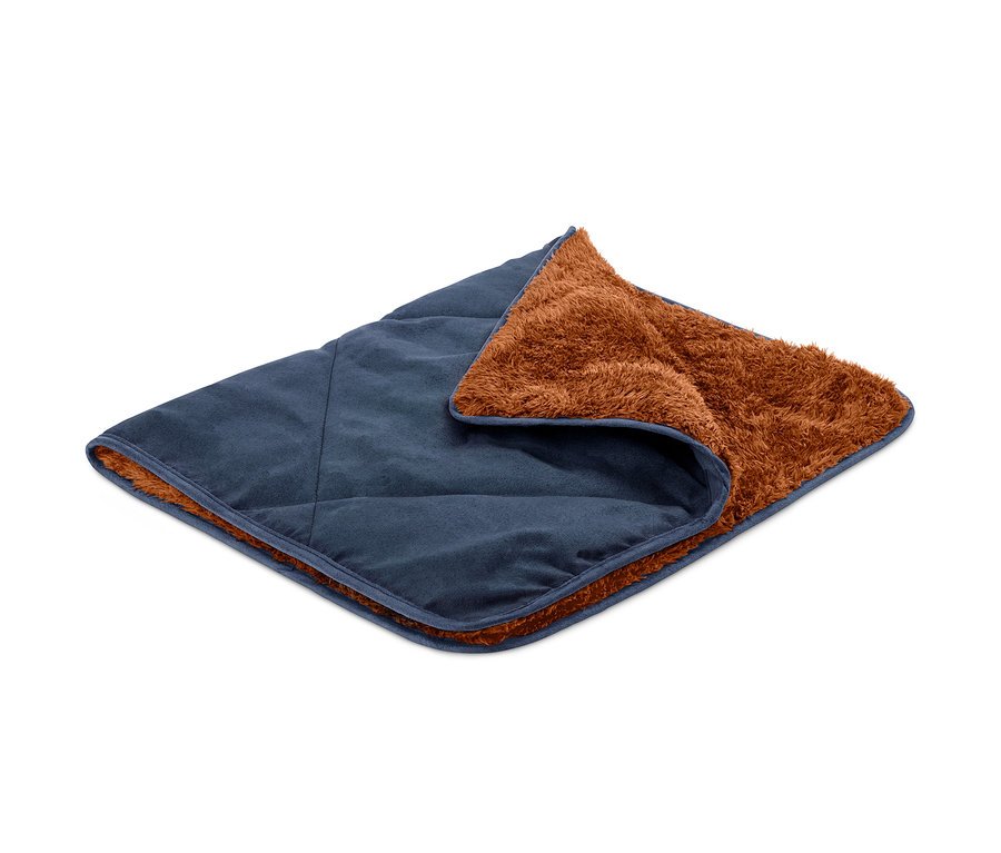 Eine Hunde-Kuscheldecke, blau mit braunem Fellfutter, liegt gefaltet auf einem weißen Hintergrund.