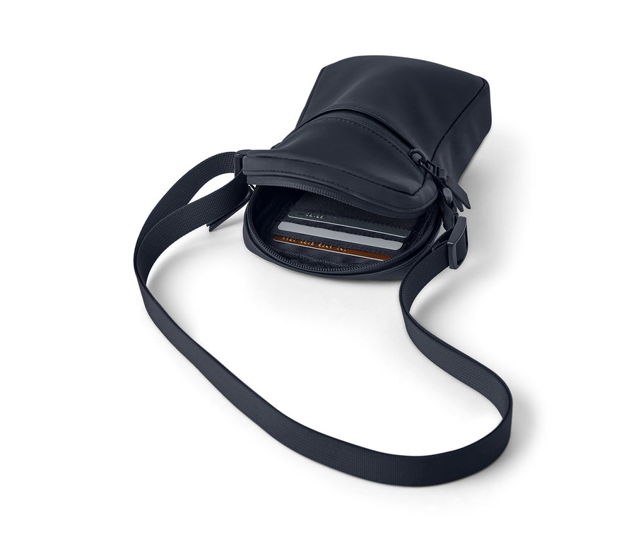 Eine marineblaue Regen-Umhängetasche mit Riemen und Reißverschluss, im Inneren sind Karten sichtbar.