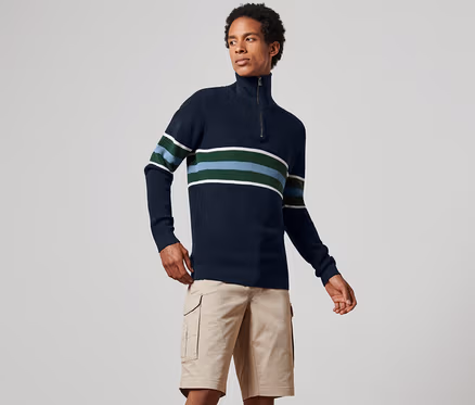 Mann trägt einen dunkelblauen Troyer-Pullover mit Streifen und Khaki-Shorts.
