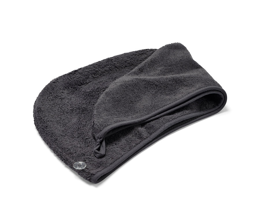 Ein anthrazitfarbenes Turban-Handtuch liegt gefaltet auf einem weißen Hintergrund.