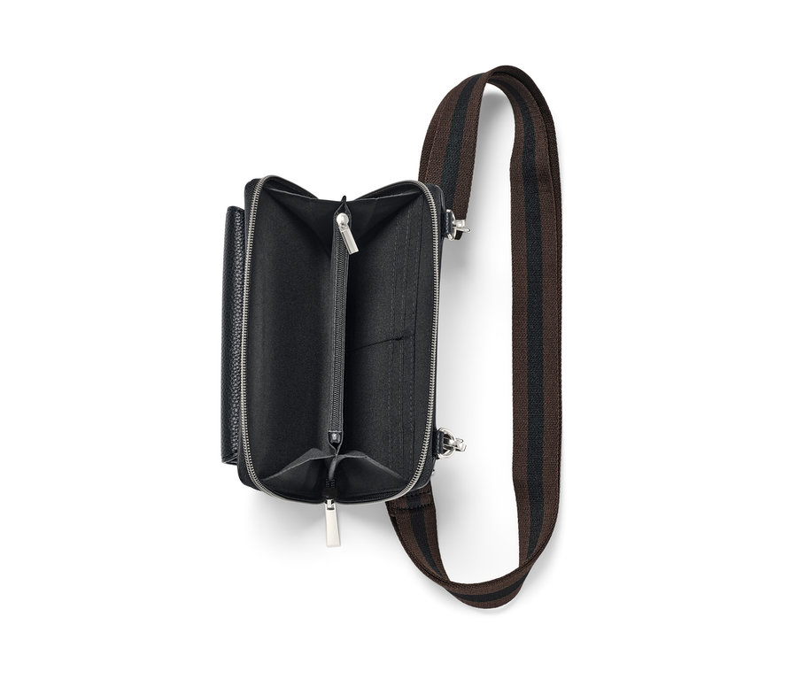 Geöffnete schwarze Mini-Tasche mit braunem Gurt.