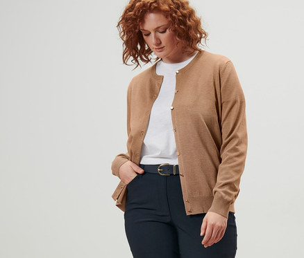 Frau trägt Feinstrick-Cardigan, Ledergürtel und dunkelblaue Bengalin-Hose.