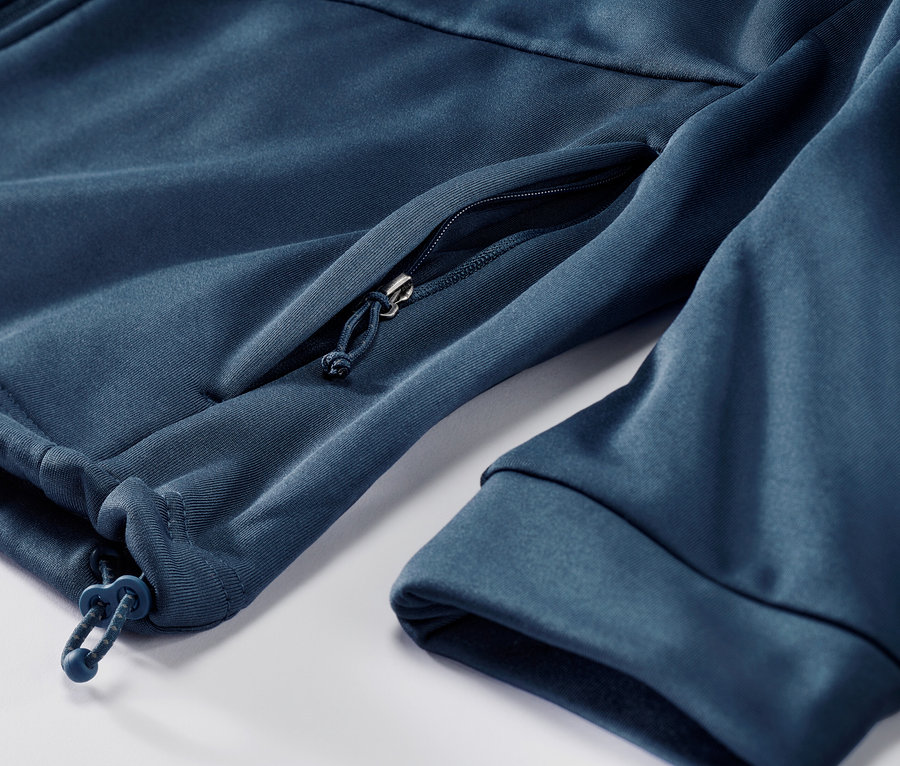 Detailaufnahme einer dunkelblauen Thermojacke mit Reißverschlusstasche.