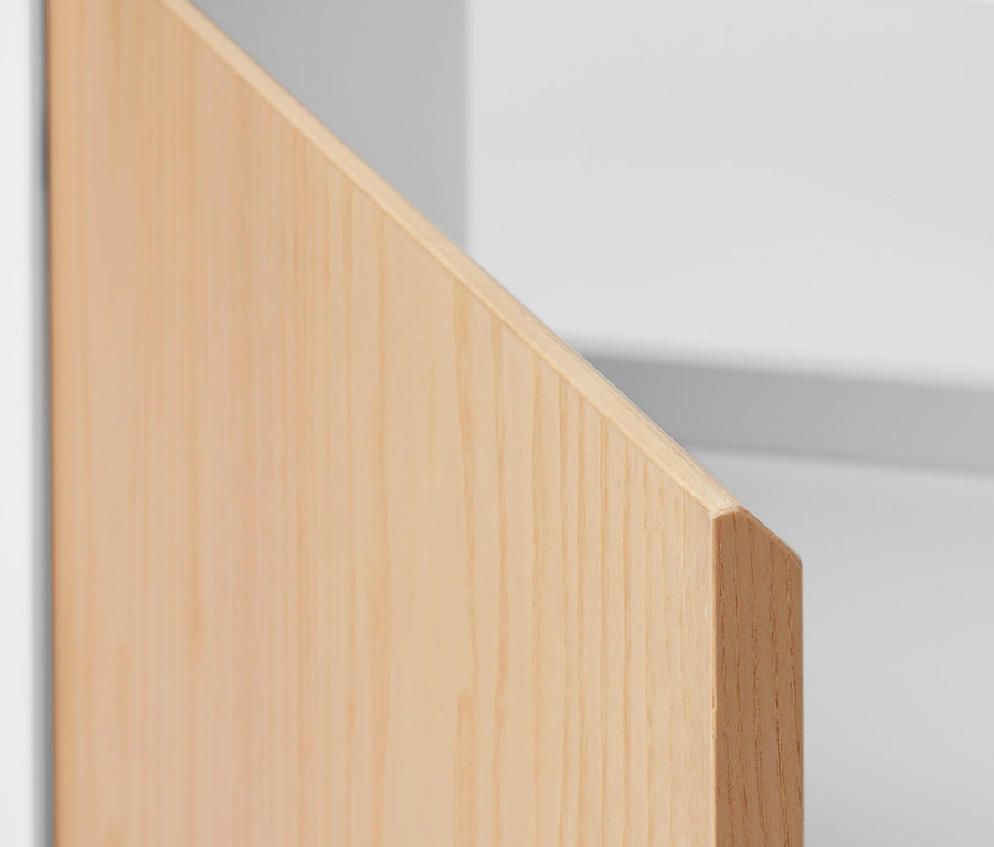 Detailansicht eines Waschbeckenunterschranks mit Tür und seitlichem Fach.