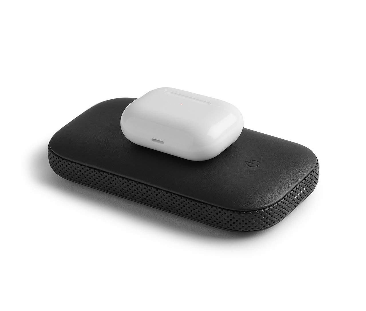 Ein Kopfhörer-Etui liegt auf einem Lexon »POWERSOUND« Lautsprecher mit Powerbank.