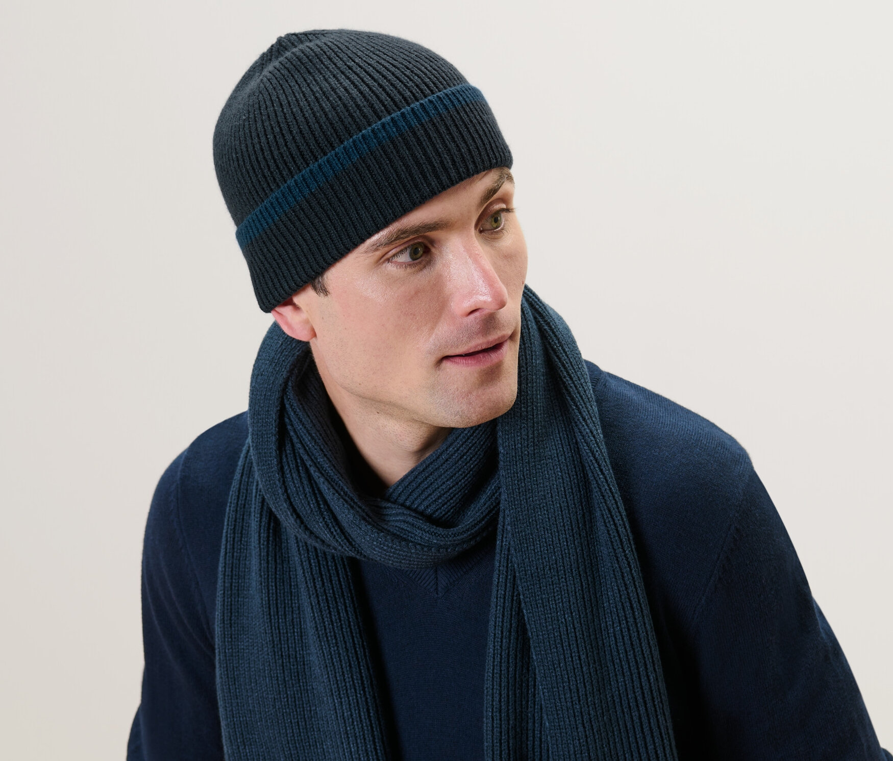 Mann trägt eine Strickmütze und einen Schal.