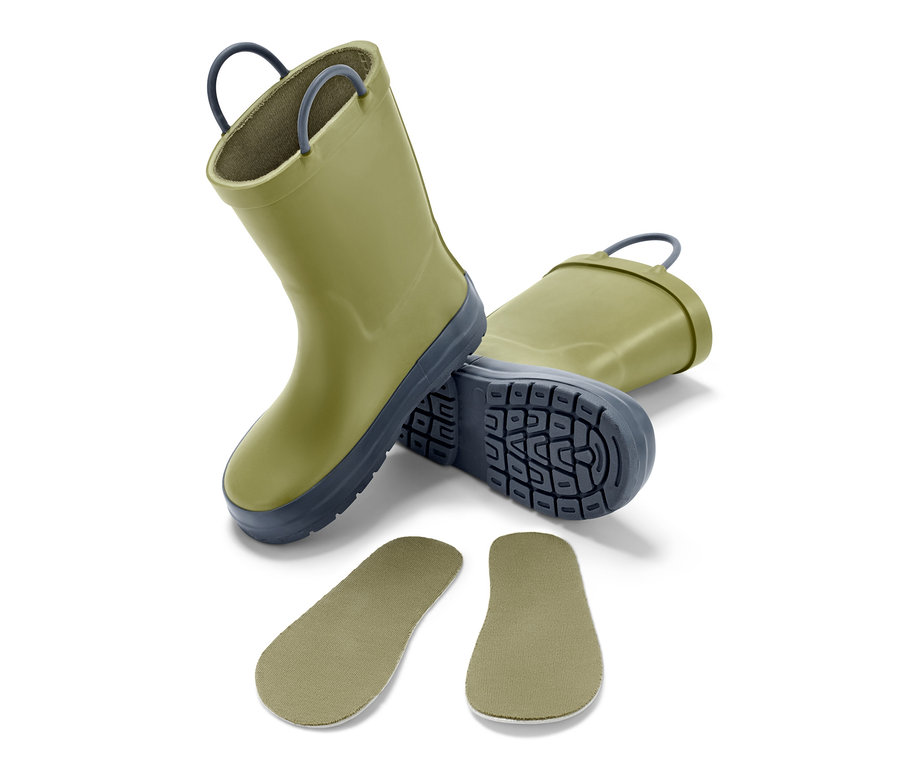 Zwei grüne Gummistiefel und zwei Einlegesohlen liegen auf einem weißen Hintergrund.