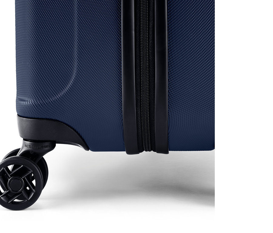 Detailansicht eines blauen Hartschalen-Koffers mit Reißverschluss und Rollen.