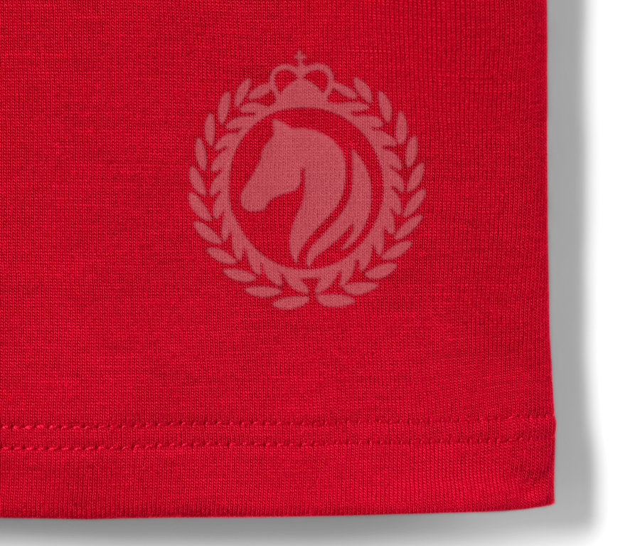 Detailansicht eines roten Kinder-Funktionsshirts mit Pferde-Logo.