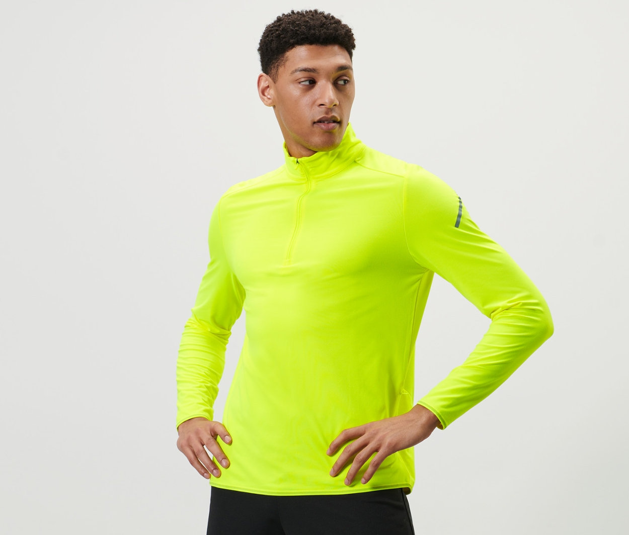 Mann posiert in neongelbem Thermo-Funktionsshirt.