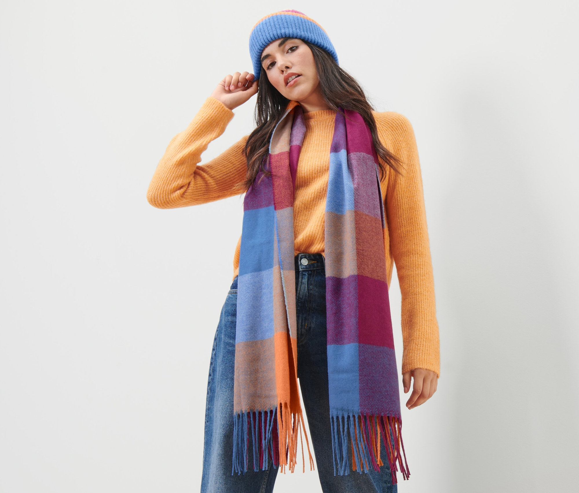 Frau trägt eine blaue Mütze und einen Schal.