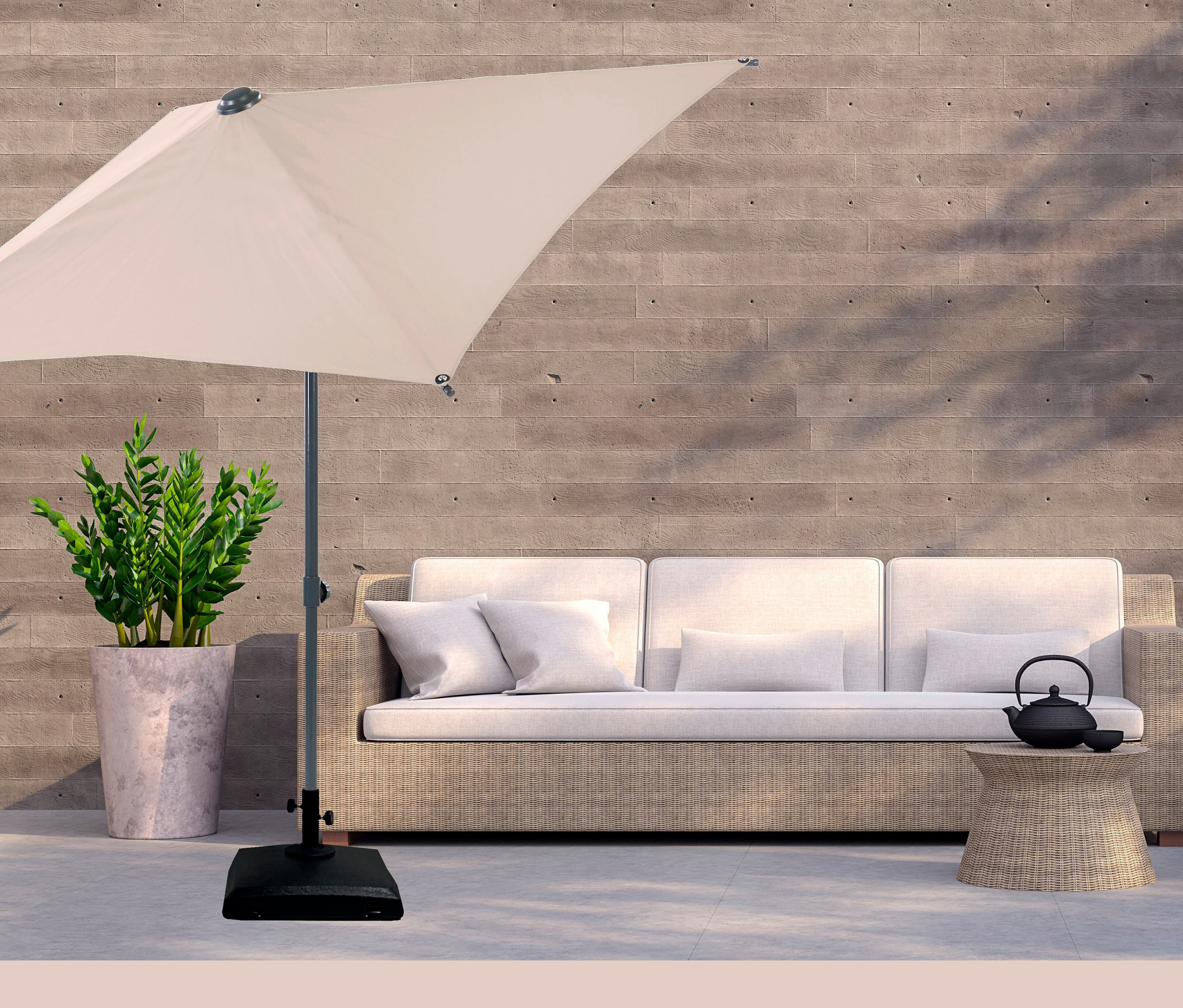 Ein cremefarbener Sonnenschirm steht neben einem Sofa, einem Tisch mit Teekanne und einer Topfpflanze. LECO Kunststoff-Sonnenschirmständer mit Rollen.