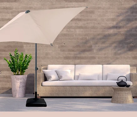 Ein cremefarbener Sonnenschirm steht neben einem Sofa, einem Tisch mit Teekanne und einer Topfpflanze. LECO Kunststoff-Sonnenschirmständer mit Rollen.