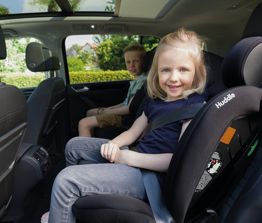 Mädchen sitzt im Osann Kindersitz »Huddle 2« im Auto, hinter ihr sitzt ein Junge.