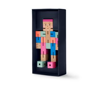 Hölzerne IQ-Puzzlefigur in Form einer Figur in einer blauen Schachtel.