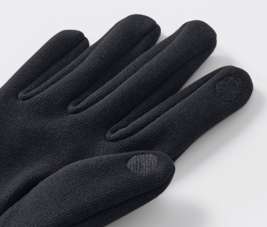 Nahaufnahme von schwarzen Sweathandschuhen auf hellem Hintergrund.