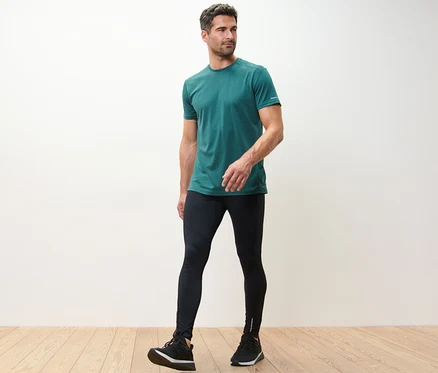 Mann in grünem T-Shirt und schwarzen Lauftights.