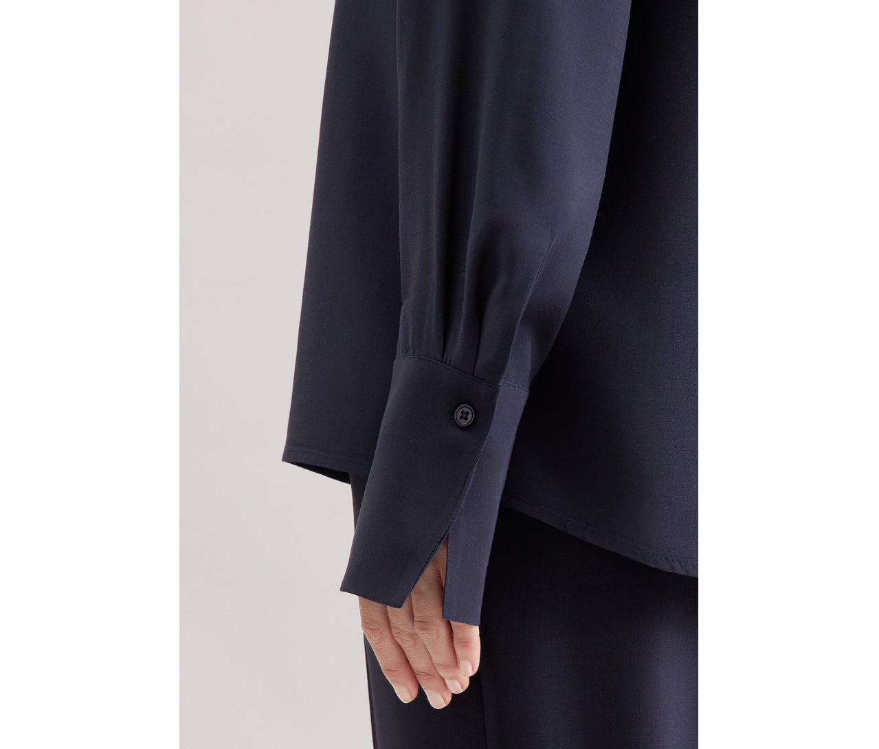 Detailansicht einer Marineblauen Seidensticker Tunika aus Viskose, die den Ärmel und einen Teil des Oberkörpers zeigt.