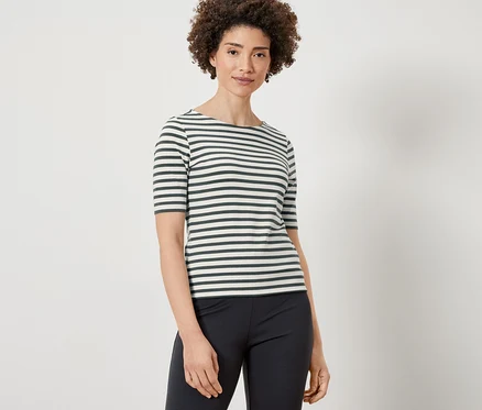 Frau trägt ein grün gestreiftes Halbarmshirt und eine schwarze Hose.