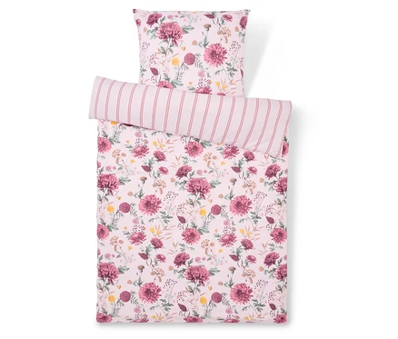 Bettwäsche mit Blumenmuster und gestreiftem Kissen.